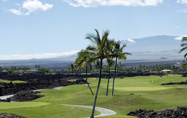 surrounding community with a yard, view of golf course, and a mountain view