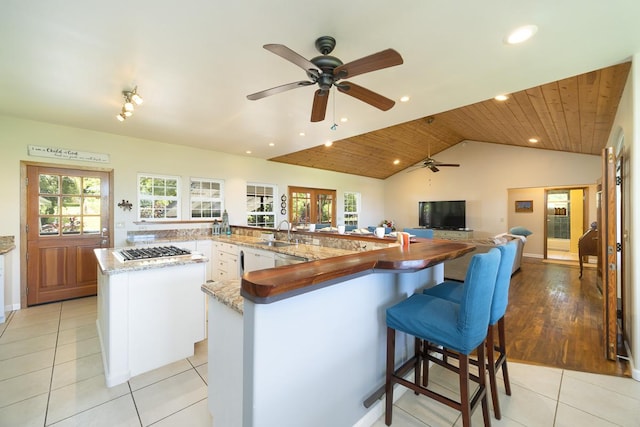 kitchen featuring a sink, plenty of natural light, light tile patterned flooring, and a spacious island