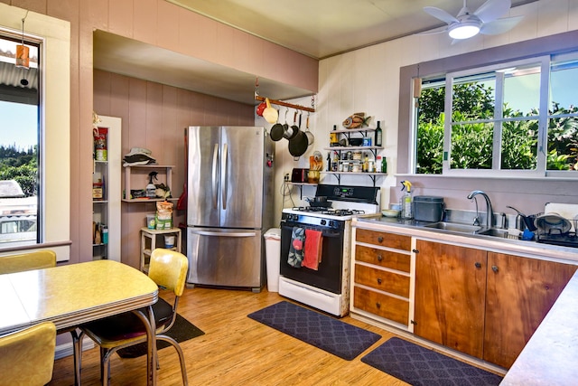 29-3871 Kanna Rd, Hakalau, HI 96710 - kitchen with gas range oven, freestanding refrigerator, light wood-style flooring, a ceiling fan, and a sink