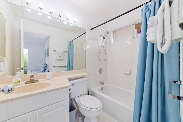 bathroom featuring toilet, shower / bath combo with shower curtain, and vanity