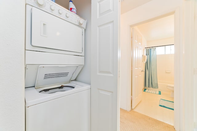 laundry room with carpet floors, stacked washer / drying machine, laundry area, and tile patterned floors