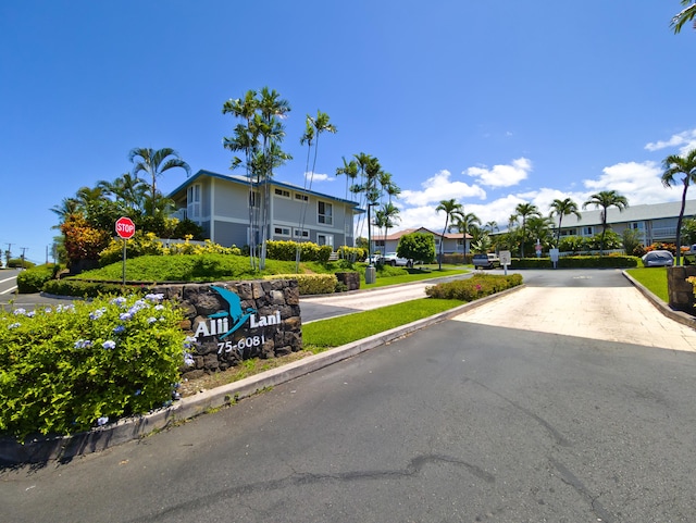 view of road featuring traffic signs, a residential view, and curbs