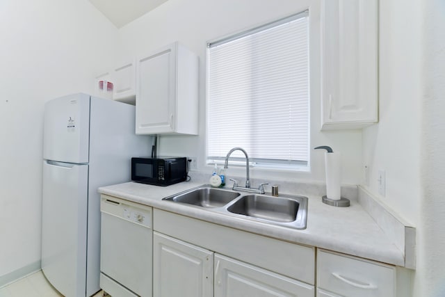 kitchen featuring black microwave, dishwasher, light countertops, white cabinetry, and a sink