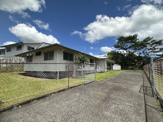 exterior space featuring an outbuilding, a storage shed, fence private yard, and a lawn