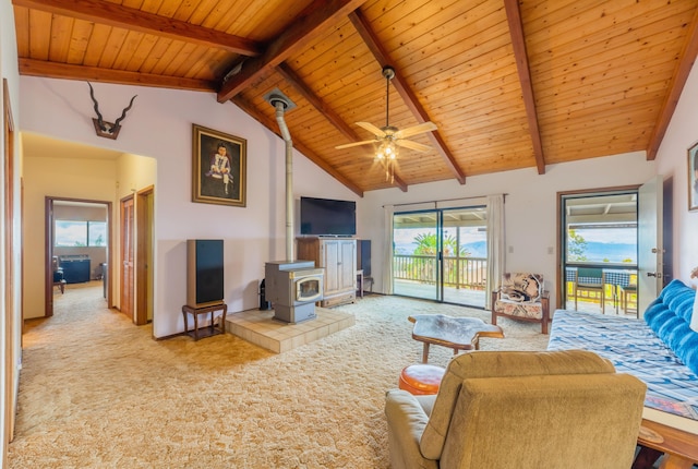 living room with high vaulted ceiling, a wood stove, light carpet, and beamed ceiling