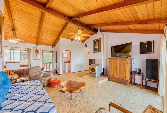 carpeted living area with vaulted ceiling with beams, wood ceiling, a wood stove, and a ceiling fan