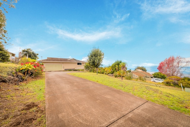 single story home with a garage, driveway, and a front yard