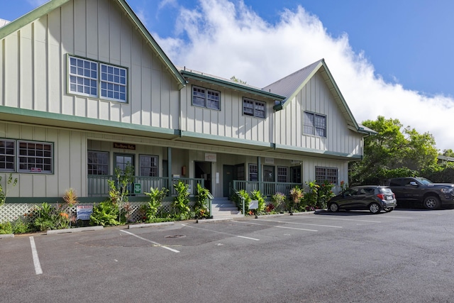 view of front of house with covered porch, uncovered parking, and board and batten siding