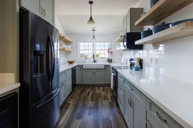 kitchen featuring dark wood-style floors, stainless steel appliances, gray cabinetry, open shelves, and a sink