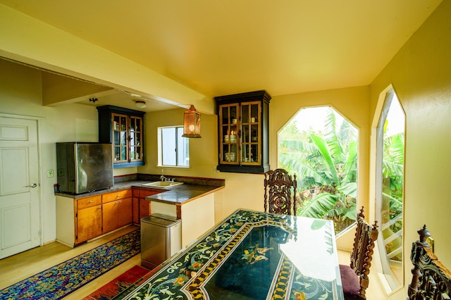 2239 Upper Kanaio Rd, Kula, HI 96790 - kitchen featuring dark countertops, a sink, light wood-style floors, and glass insert cabinets