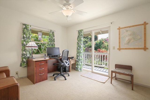 office space with a ceiling fan and light carpet