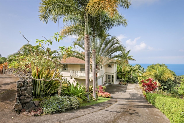 view of front of property with concrete driveway and a water view