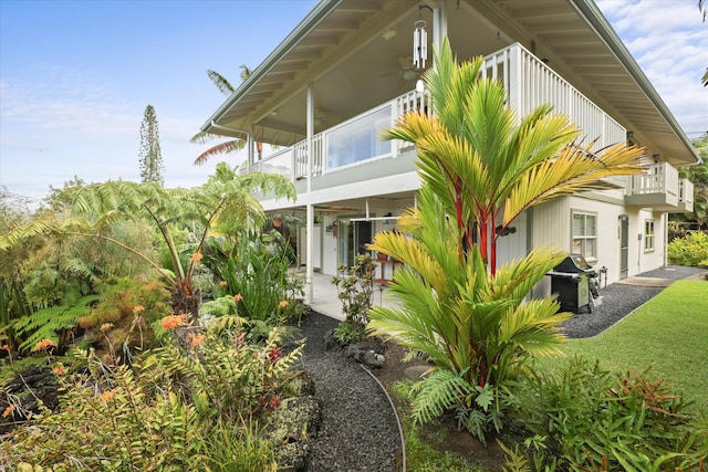 view of property exterior with a patio area and a balcony