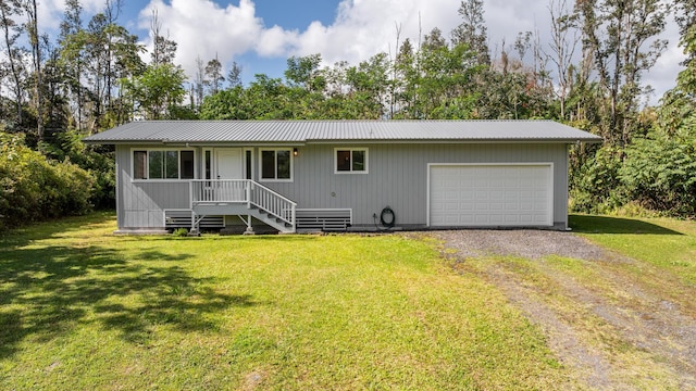 view of front of property with metal roof, a front yard, and driveway