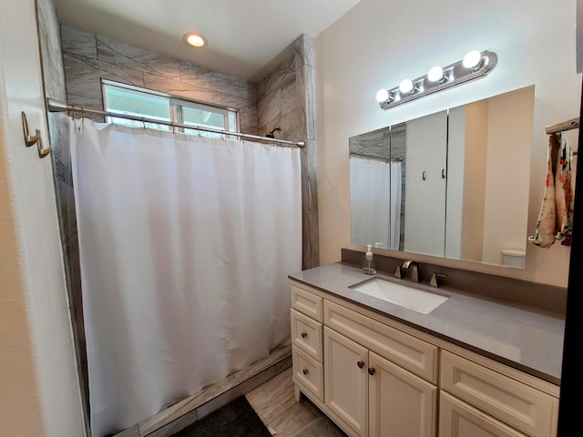 bathroom featuring curtained shower, vanity, and recessed lighting