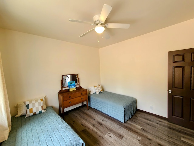 bedroom featuring dark wood-type flooring, a ceiling fan, and baseboards