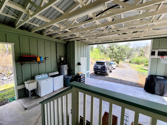 view of patio with water heater, separate washer and dryer, a sink, and an attached carport