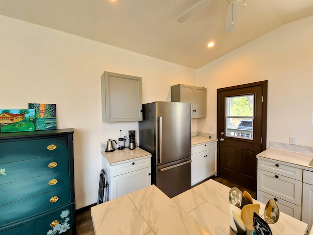 kitchen featuring dark wood finished floors, light countertops, gray cabinetry, freestanding refrigerator, and vaulted ceiling