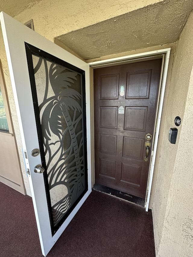 property entrance with stucco siding