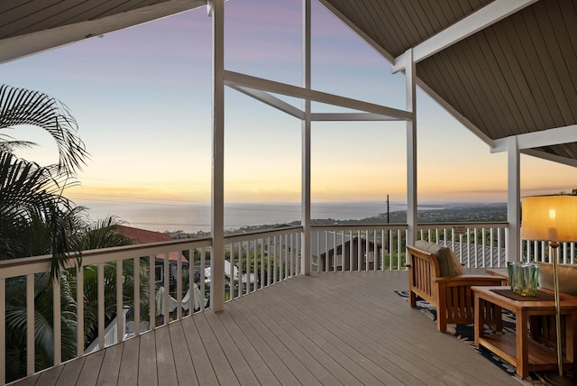 deck at dusk featuring a water view