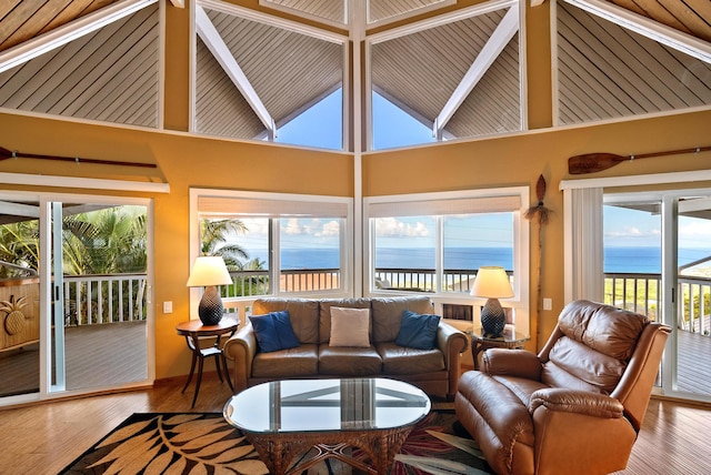 sunroom featuring lofted ceiling with beams and a water view