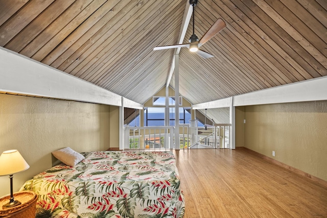 unfurnished bedroom with a wall of windows, vaulted ceiling, and wood finished floors