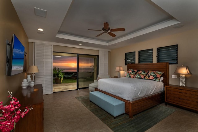 bedroom featuring a tray ceiling, access to outside, tile patterned floors, and recessed lighting