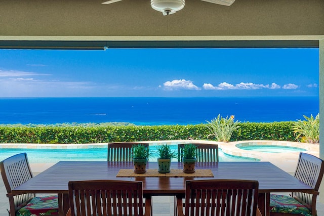 exterior space featuring outdoor dining area, a water view, a swimming pool, and an in ground hot tub