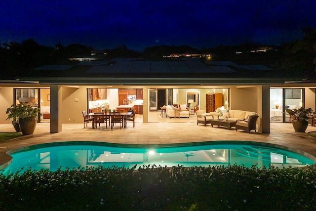 back of house at twilight with an outdoor pool, a patio, an outdoor living space, and stucco siding