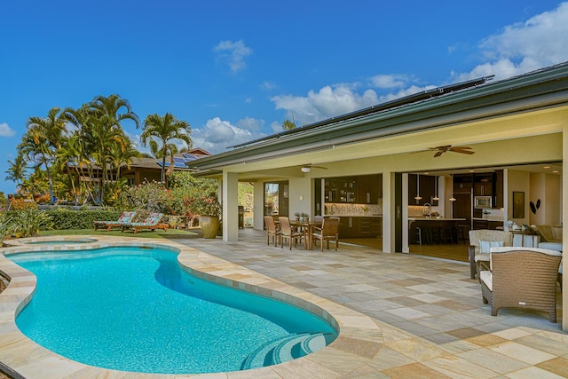 pool featuring ceiling fan, an in ground hot tub, outdoor dining space, and a patio