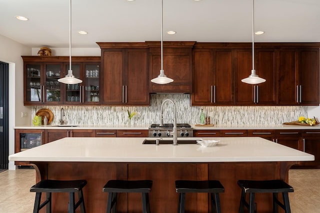 kitchen featuring decorative backsplash, wine cooler, glass insert cabinets, light countertops, and a sink