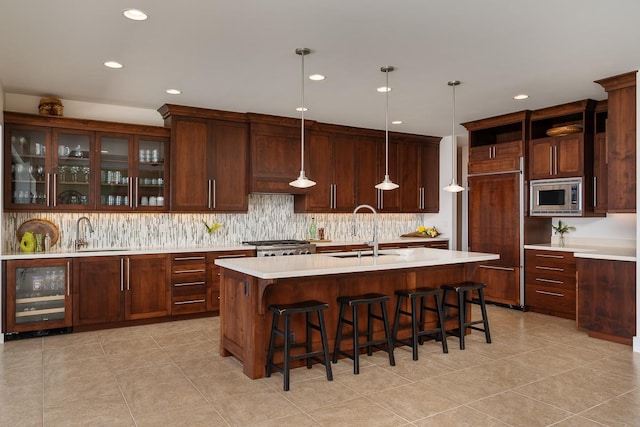 kitchen featuring light countertops, wine cooler, stainless steel microwave, and a sink