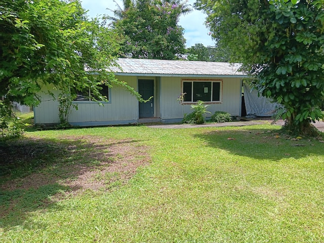 ranch-style home with metal roof and a front lawn