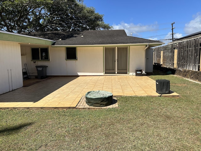 rear view of property with fence, a lawn, and a patio