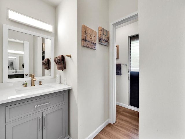 bathroom featuring vanity, baseboards, and wood finished floors