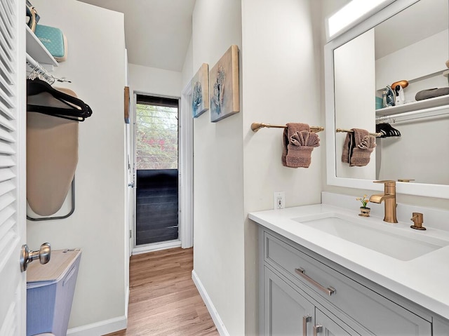 bathroom with vanity, baseboards, and wood finished floors