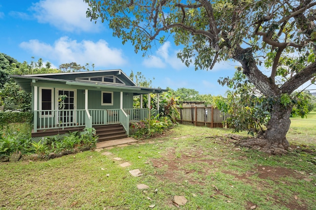 view of front facade featuring a porch, a front yard, and fence