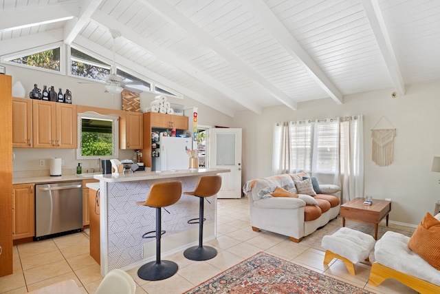 kitchen with open floor plan, a breakfast bar, freestanding refrigerator, light countertops, and stainless steel dishwasher