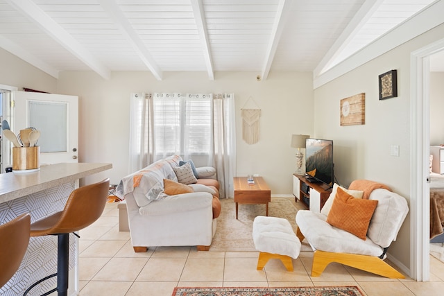 living room featuring lofted ceiling with beams, light tile patterned floors, and baseboards