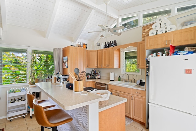 kitchen with dishwasher, freestanding refrigerator, light countertops, a sink, and light tile patterned flooring