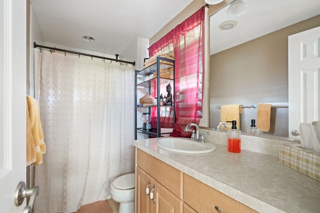 bathroom featuring toilet, vanity, and a shower with curtain