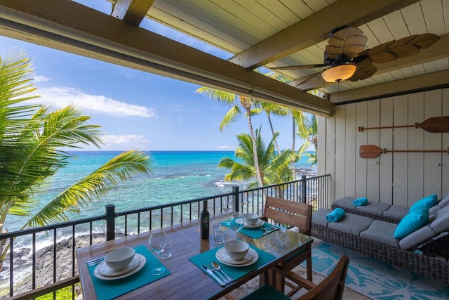 balcony with an outdoor hangout area, ceiling fan, and a water view