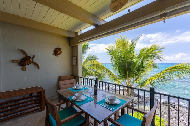 balcony with a water view and a view of the beach