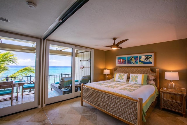 bedroom with a water view, a textured ceiling, a ceiling fan, and access to outside