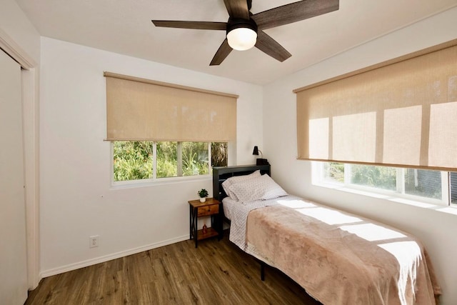 bedroom with multiple windows, ceiling fan, baseboards, and wood finished floors