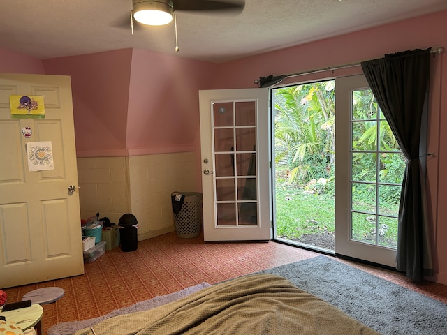 doorway with ceiling fan and concrete block wall