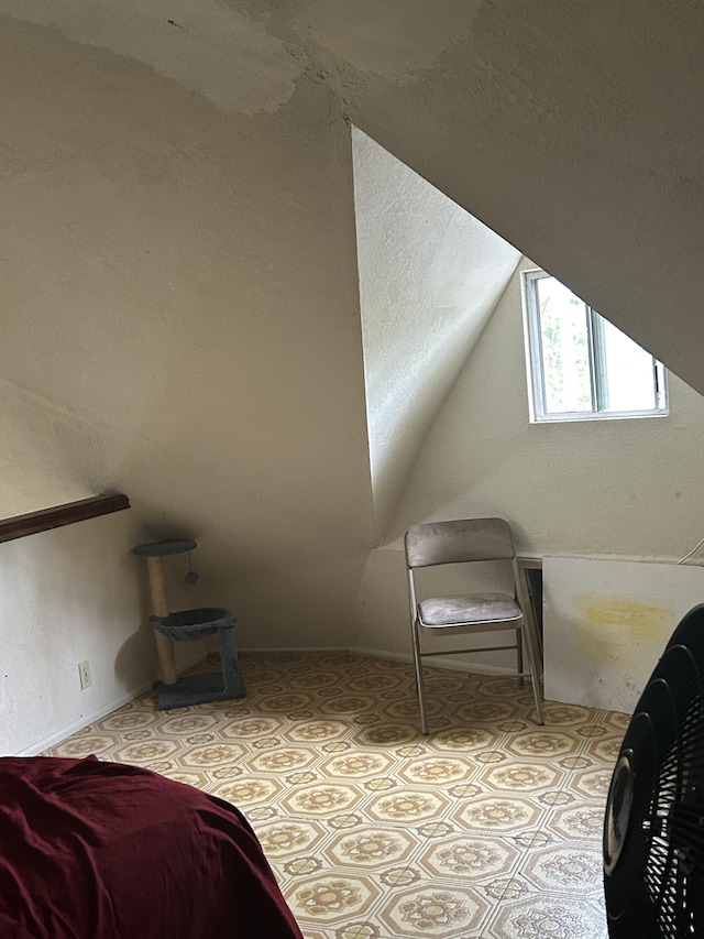 bedroom featuring light floors and vaulted ceiling