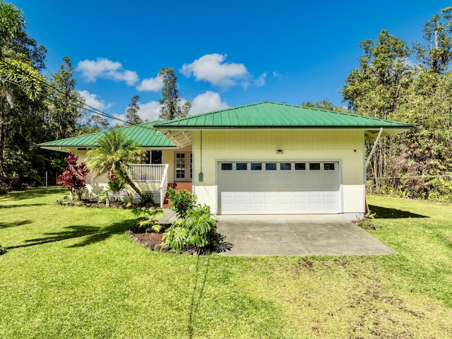 ranch-style house featuring driveway, a garage, metal roof, and a front yard