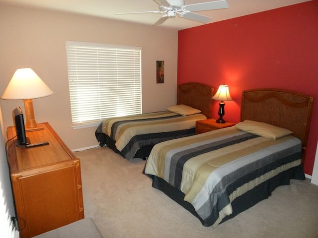 carpeted bedroom with ceiling fan and baseboards