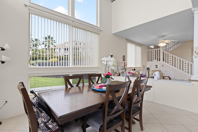 dining area featuring a healthy amount of sunlight, stairway, a high ceiling, and light tile patterned floors